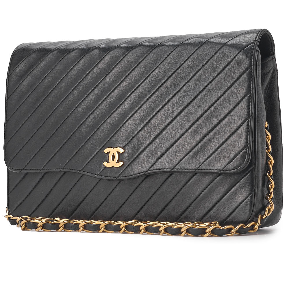 Sac bandoulière d'occasion en cuir d'agneau noir avec coutures en biais et fermoir à pression, quincaillerie dorée.