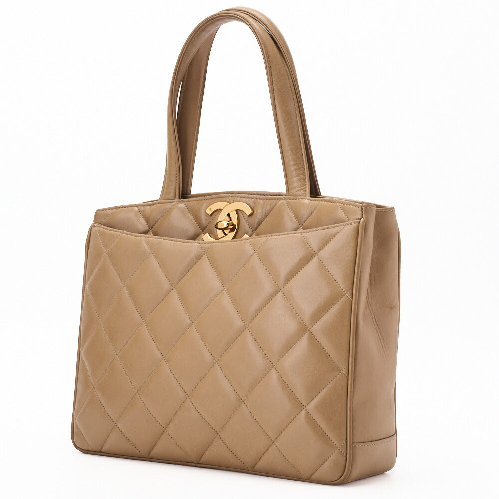 Sac à main d'occasion matelassé avec fermoir tournant en cuir d'agneau beige et matériel doré. D'occasion
